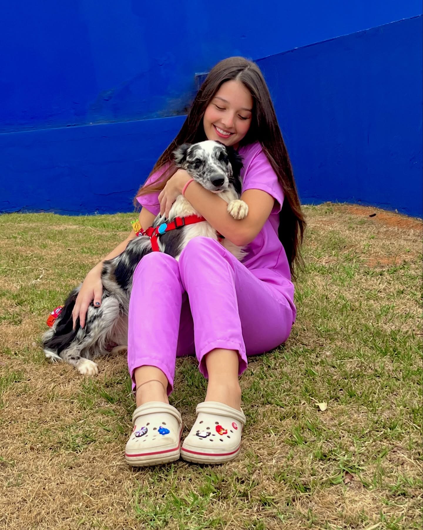 Samires sentada com um cão em momento de cuidado